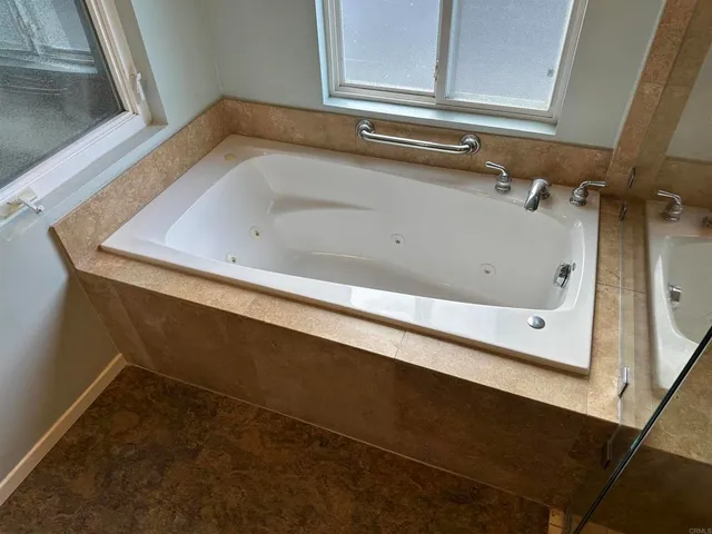 a bathroom with a bathtub and a window