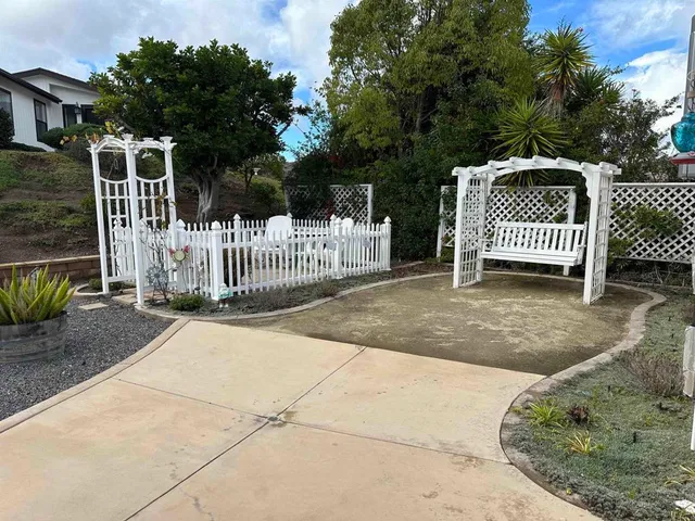 a view of a brick house with a small yard and wooden fence