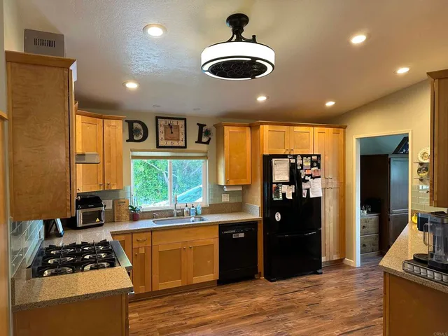 a kitchen with stainless steel appliances kitchen island granite countertop a refrigerator stove and cabinets