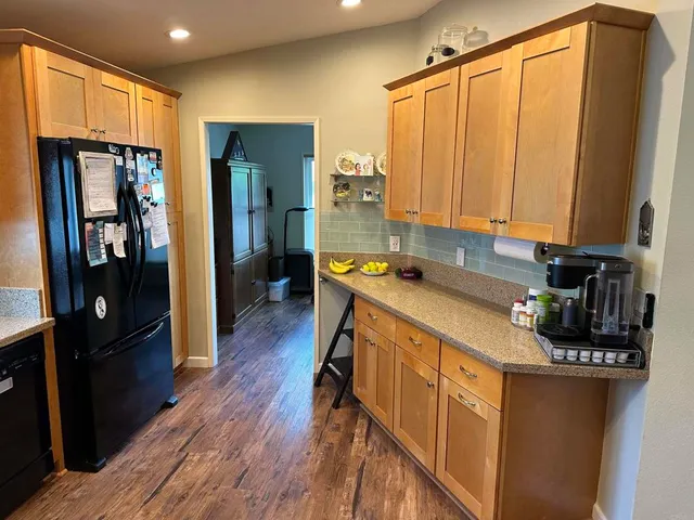 a kitchen with stainless steel appliances granite countertop a refrigerator a stove and a wooden cabinets