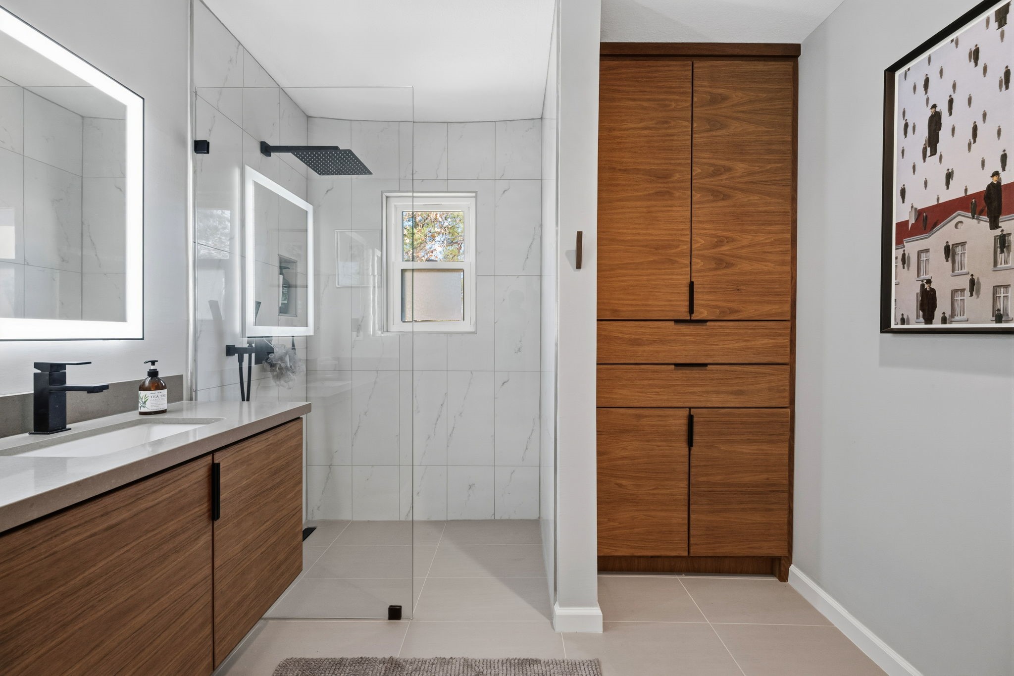 1831 Palm Street Houston, TX 77004 - Photo 17 of 27 This modern bathroom features a sleek design with a spacious glass shower, illuminated mirror, and stylish wood cabinetry for extra storage.