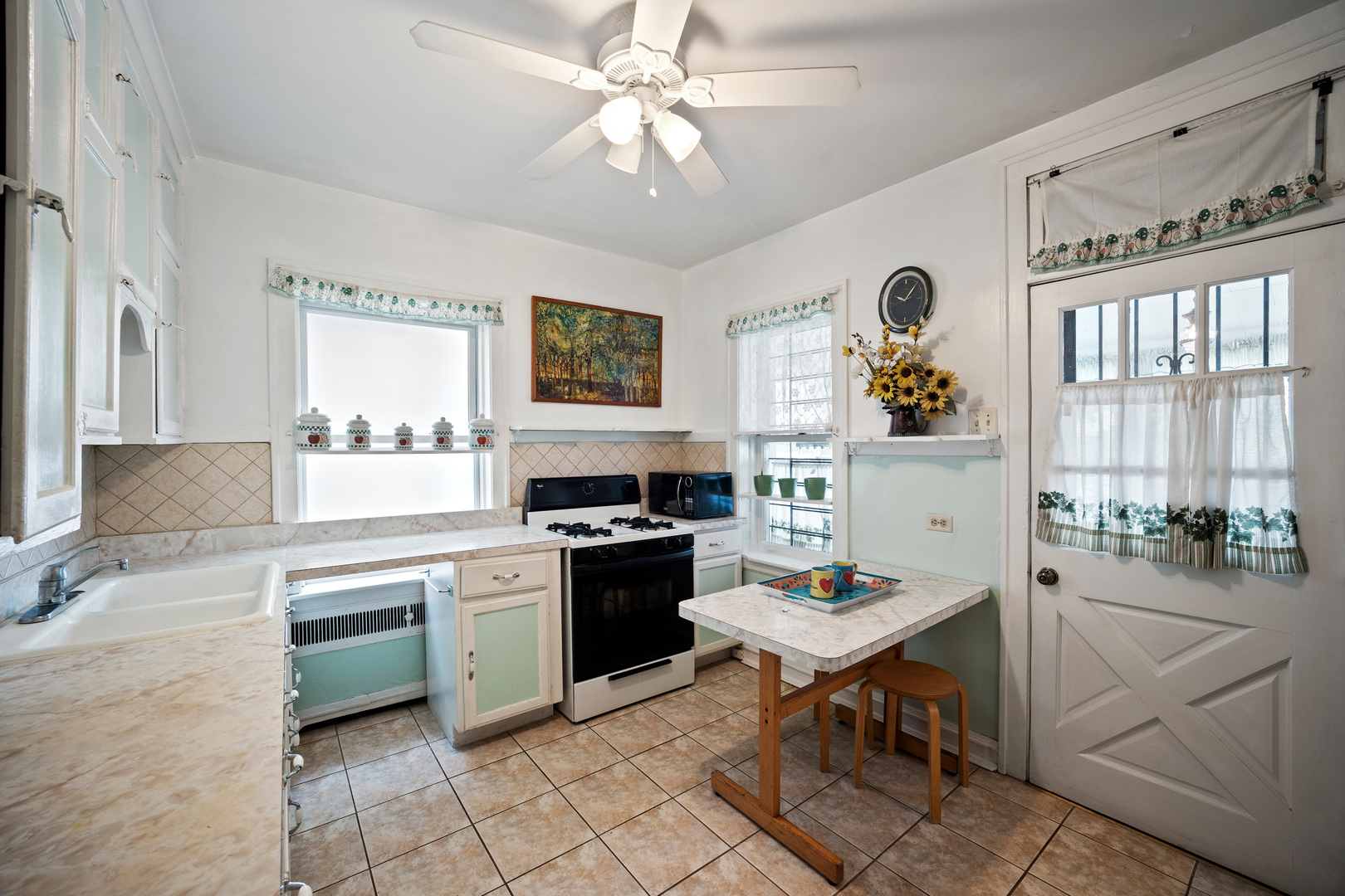 5124 West Nelson Street Chicago, IL 60641 - Photo 10 of 21 a open kitchen with stainless steel appliances granite countertop a stove top oven a sink a dining table and chairs with the cabinets