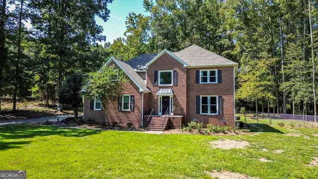 a front view of a house with yard and green space
