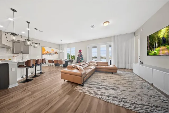 a kitchen with stainless steel appliances kitchen island granite countertop a table chairs and a wooden floor