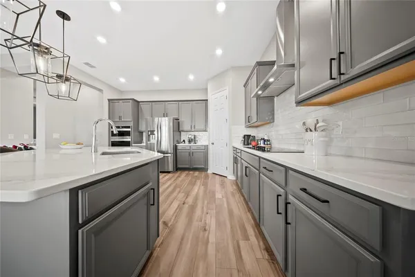 a kitchen with stainless steel appliances granite countertop a sink and refrigerator