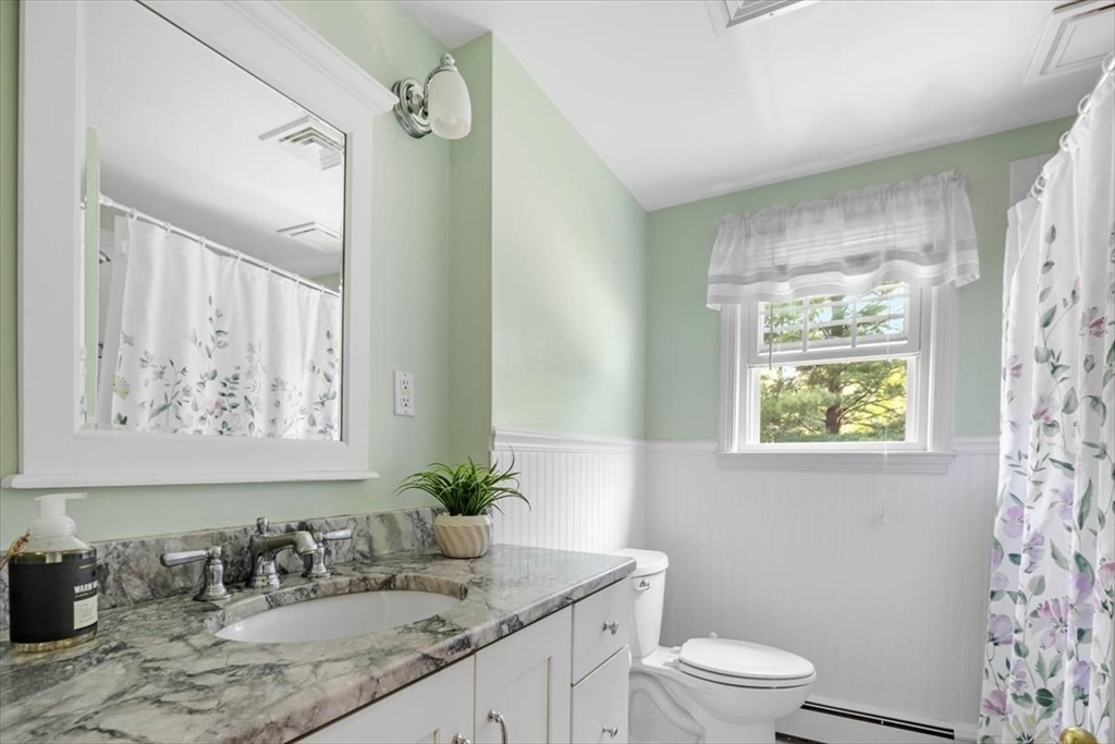 60 Old County Road Hingham, MA 02043 - Photo 21 of 32 a bathroom with a granite countertop sink a toilet a mirror and shower curtain
