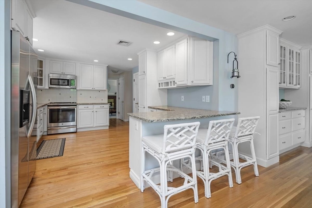 60 Old County Road Hingham, MA 02043 - Photo 10 of 32 a kitchen with stainless steel appliances kitchen island granite countertop a refrigerator and cabinets