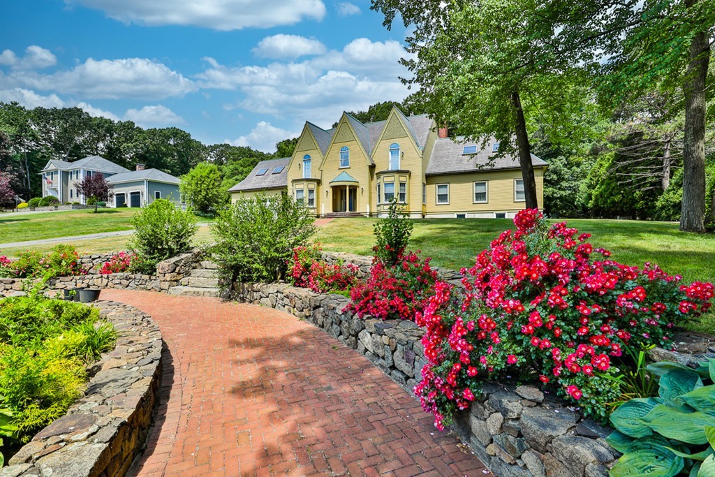 a view of a house with a big yard and flower plants
