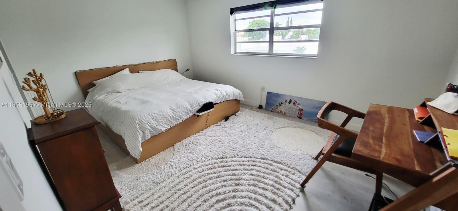 1605 Meridian Avenue, Unit 401 Miami Beach, FL 33139 - Photo 11 of 14 a bedroom with a bed and wooden floor