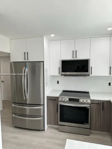 a kitchen with stainless steel appliances a stove a microwave and a refrigerator