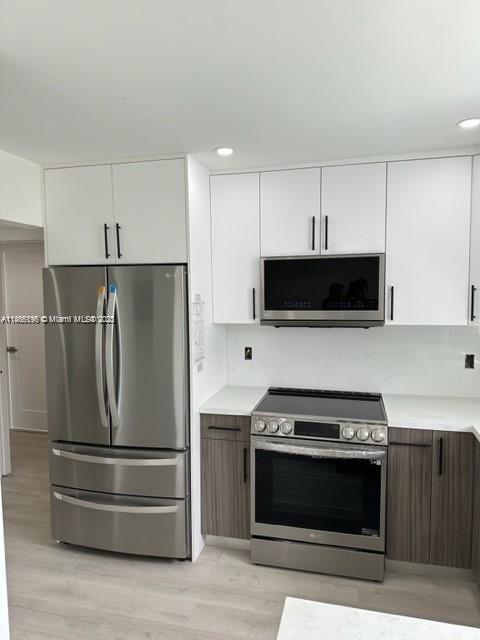 1605 Meridian Avenue, Unit 401 Miami Beach, FL 33139 - Photo 3 of 14 a kitchen with stainless steel appliances a stove a microwave and a refrigerator