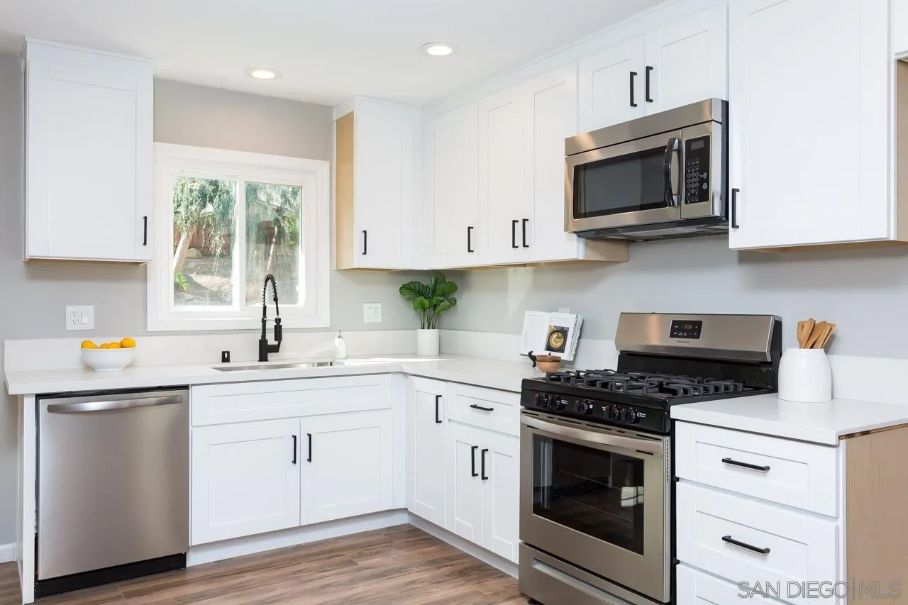 9597 Mandeville Road Santee, CA 92071 - Photo 11 of 32 a kitchen with stainless steel appliances white cabinets a sink and a stove