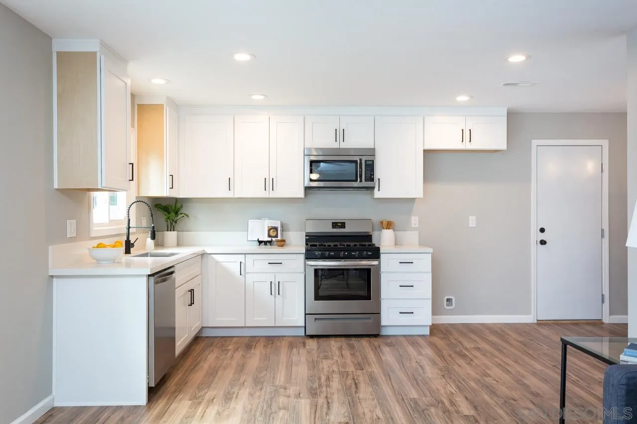 9597 Mandeville Road Santee, CA 92071 - Photo 12 of 32 a kitchen with stainless steel appliances granite countertop a stove top oven a sink a refrigerator and white cabinets
