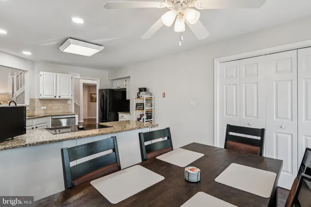 a kitchen with granite countertop kitchen island sink stove and white cabinets