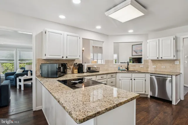 a kitchen with granite countertop a stove sink and cabinets