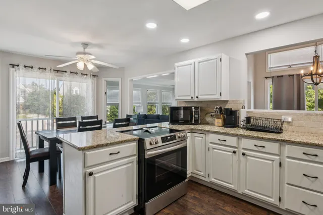 a kitchen with stainless steel appliances kitchen island granite countertop a stove a sink and a refrigerator