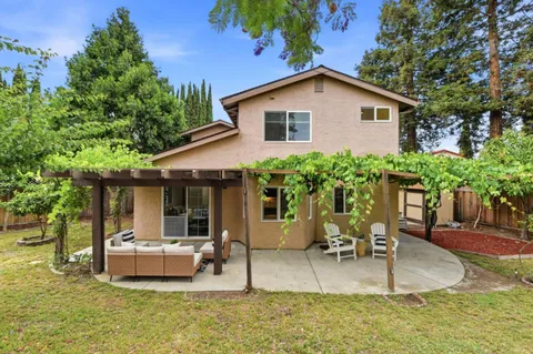 a view of house with backyard and outdoor seating