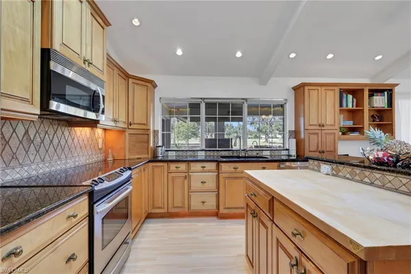 a kitchen with granite countertop a stove and cabinets