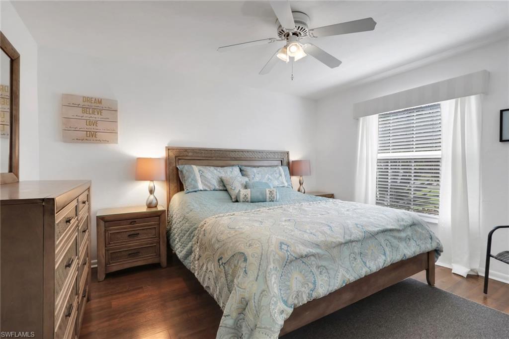 369 Hidden Valley Drive Naples, FL 34113 - Photo 24 of 49 a bedroom with a bed a dresser with wooden floor