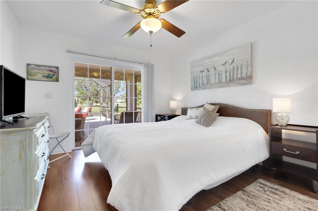 369 Hidden Valley Drive Naples, FL 34113 - Photo 27 of 49 a bedroom with a large bed a flat tv screen and a chandelier