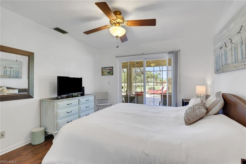 369 Hidden Valley Drive Naples, FL 34113 - Photo 28 of 49 a bedroom with a large bed and a flat tv screen on dresser