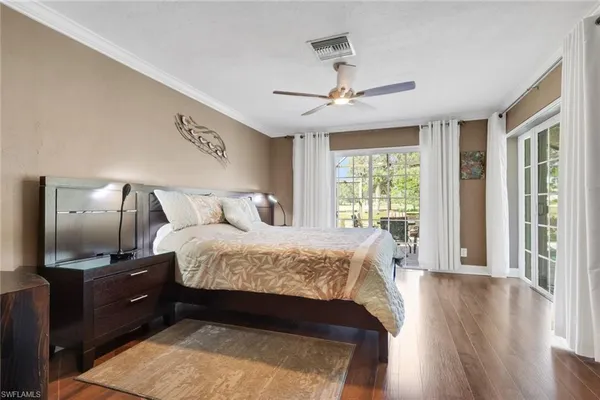 a bedroom with a large bed and wooden floor