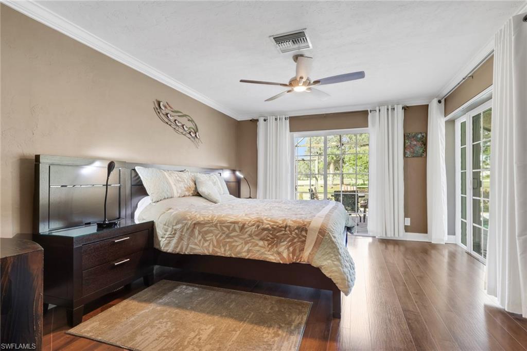 369 Hidden Valley Drive Naples, FL 34113 - Photo 29 of 49 a bedroom with a large bed and wooden floor