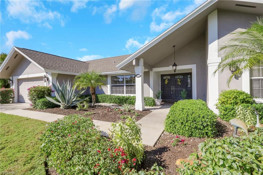 369 Hidden Valley Drive Naples, FL 34113 - Photo 3 of 49 a front view of a house with a yard and glass windows
