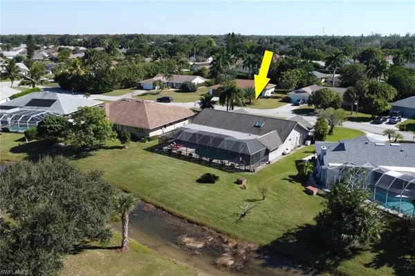 an aerial view of a house with swimming pool and tennis court