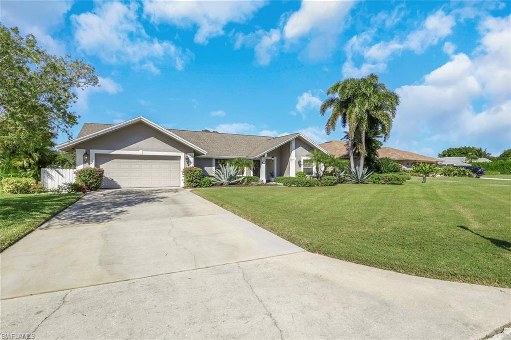 369 Hidden Valley Drive Naples, FL 34113 - Photo 48 of 49 a front view of a house with a garden and yard