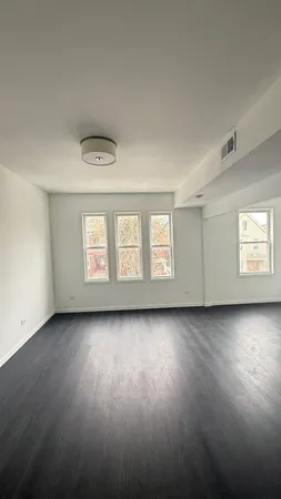 a view of a livingroom with wooden floor and window