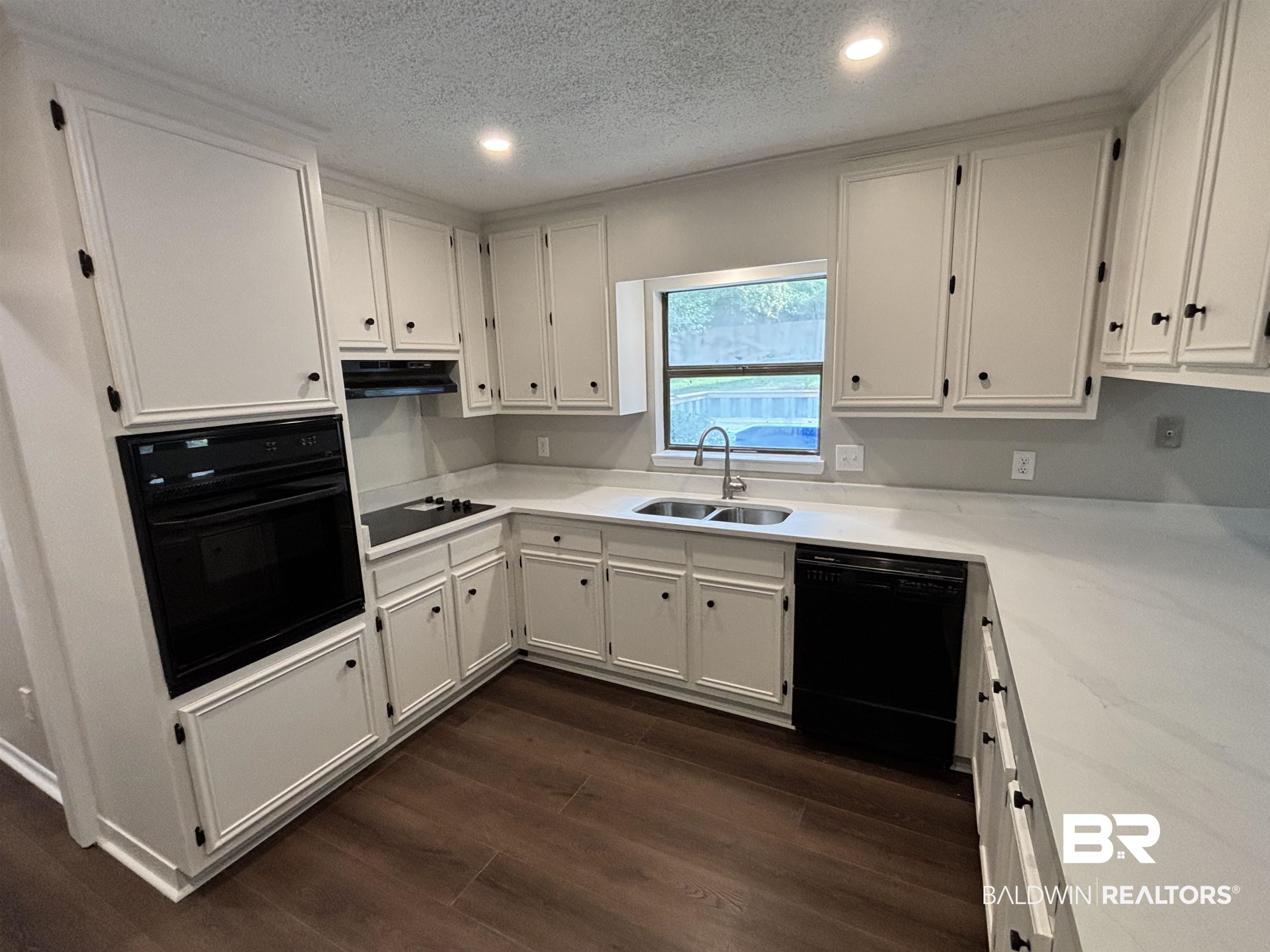 10 Soldiers Route Daphne, AL 36527 - Photo 10 of 26 Kitchen with a textured ceiling, white cabinetry, black appliances, dark wood finished floors, and recessed lighting