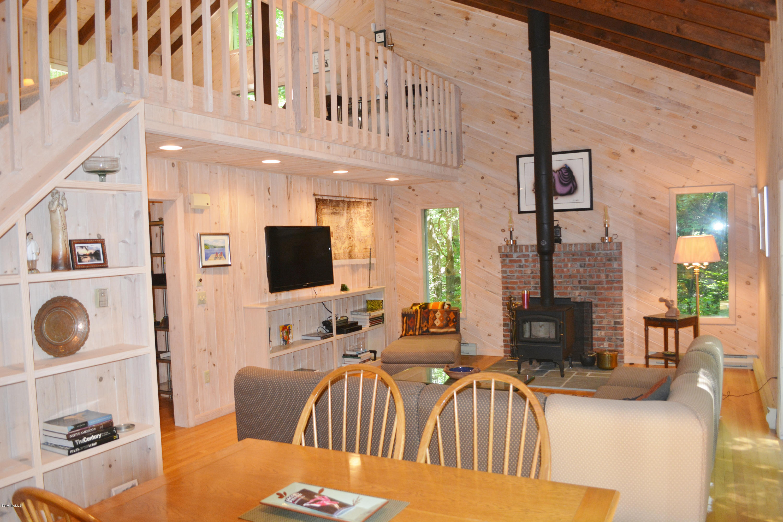 894 Moberg Road Becket, MA 01223 - Photo 2 of 21 a living room with furniture a flat screen tv and a fireplace