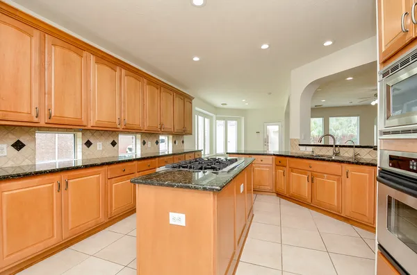 a kitchen with stainless steel appliances granite countertop a stove a sink and a microwave