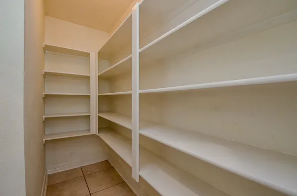 a view of walk in closet with empty racks