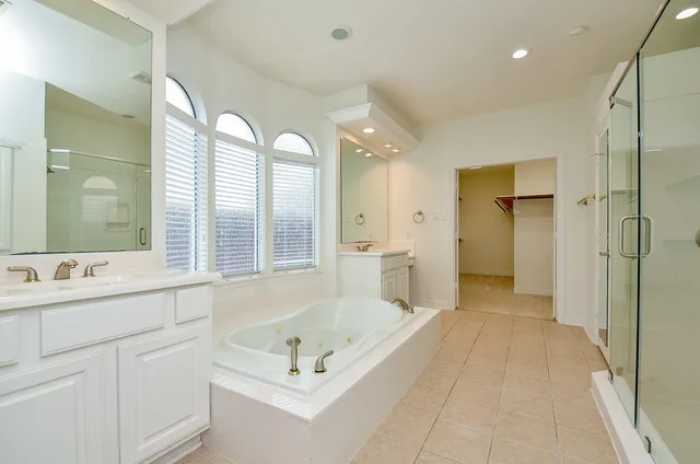 a spacious bathroom with a tub shower and sink