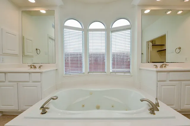 a bathroom with a tub sink and mirror