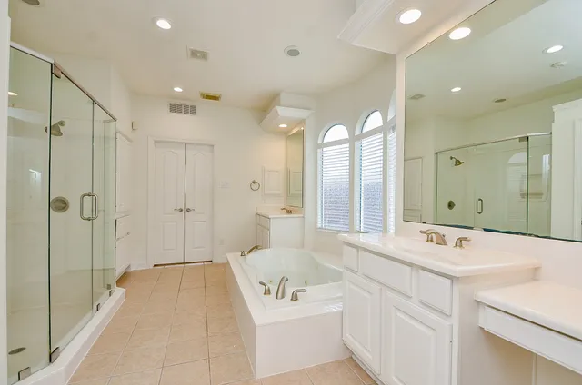 a bathroom with a tub a sink shower and mirror