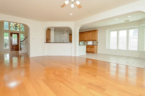 a view of an empty room with window and wooden floor