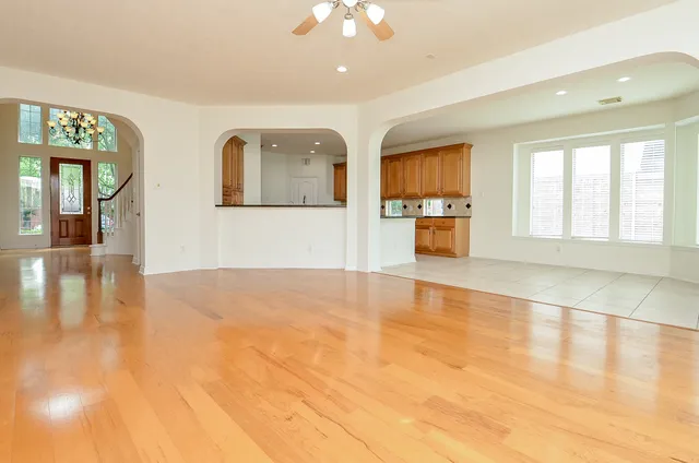 a view of an empty room with window and wooden floor