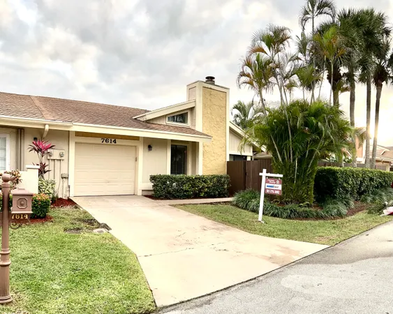 a front view of a house with a yard and potted plants