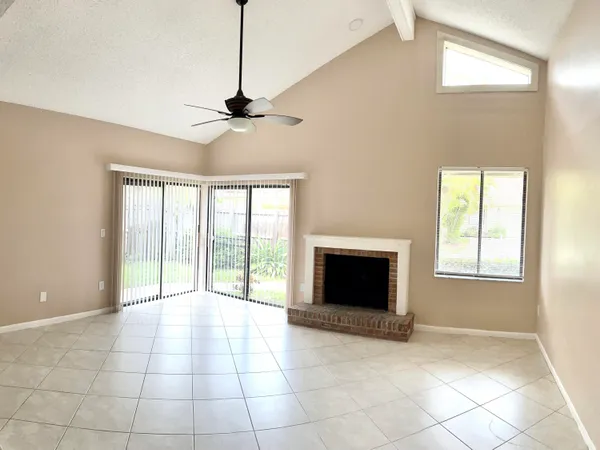 a view of an empty room with a fireplace and a window
