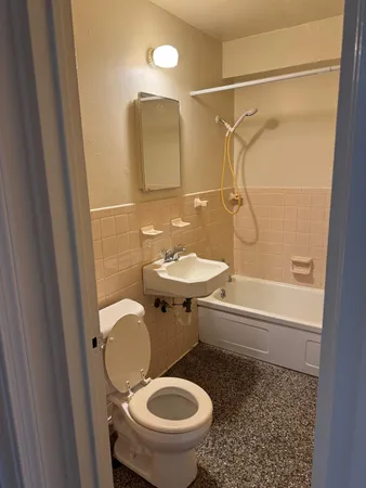a bathroom with a granite countertop toilet sink and shower