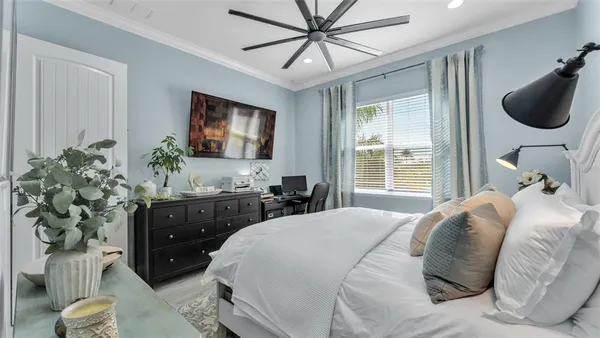 a bedroom with a large bed and a chandelier