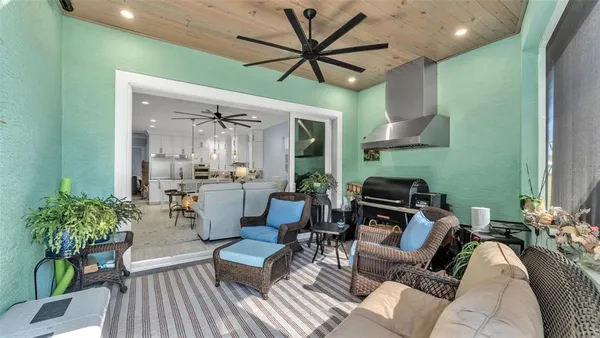 a living room with furniture a chandelier and a dining table with wooden floor