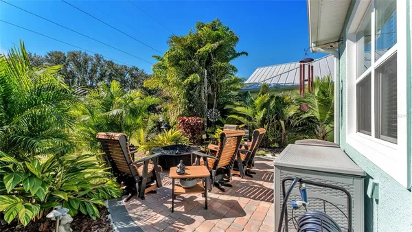 a view of a backyard with table and chairs and potted plants