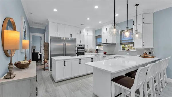 a kitchen with stainless steel appliances granite countertop a sink refrigerator and cabinets