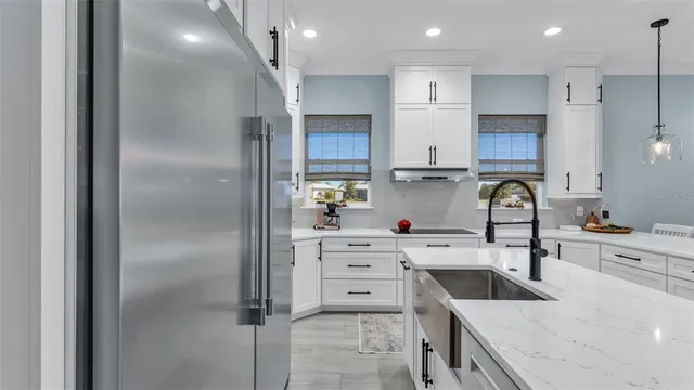 a kitchen with kitchen island white cabinets and refrigerator