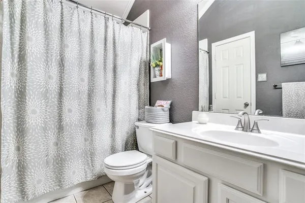 a bathroom with a sink a toilet and shower curtain