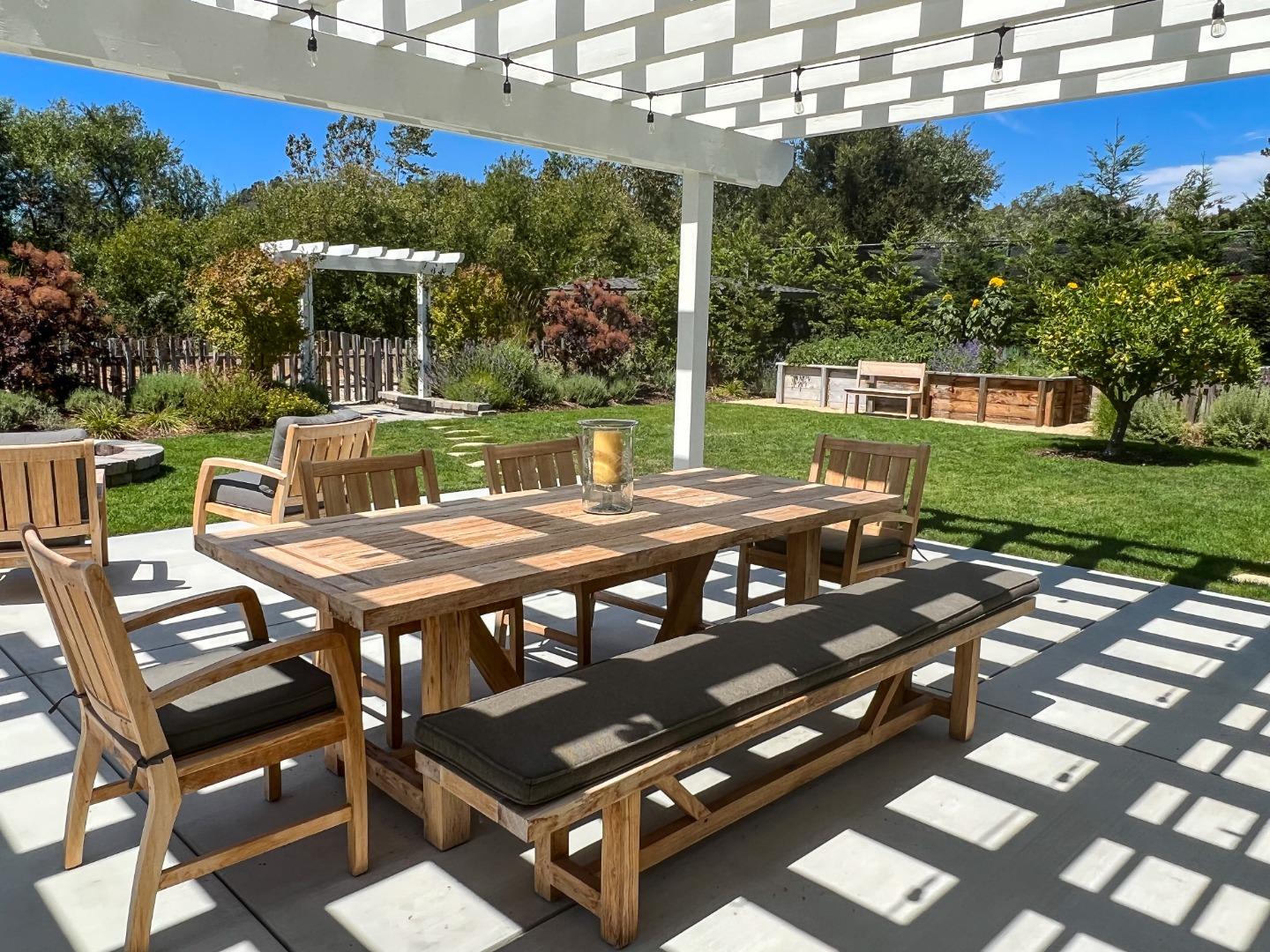 28060 Robinson Canyon Road Carmel, CA 93923 - Photo 1 of 36 a view of a patio with table and chairs with wooden floor and fence
